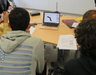 Grup d'alumnes observant les traces de radiació beta detectades amb el detector Timepix a la Facultat de Física