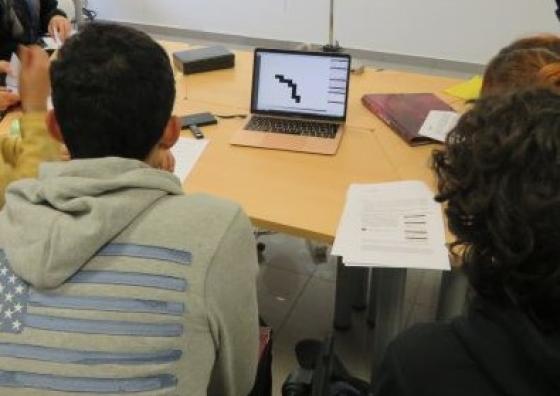 Grup d'alumnes observant les traces de radiació beta detectades amb el detector Timepix a la Facultat de Física